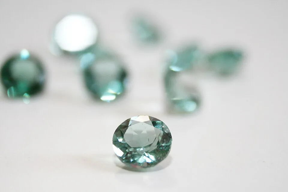 Round-cut pale green prasiolite gemstones on a white background